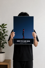 Image 2 (Desk Mockup View): Spider-Man "Under The Same Moon" wall art poster hanging above a wooden desk and black desk lamp.